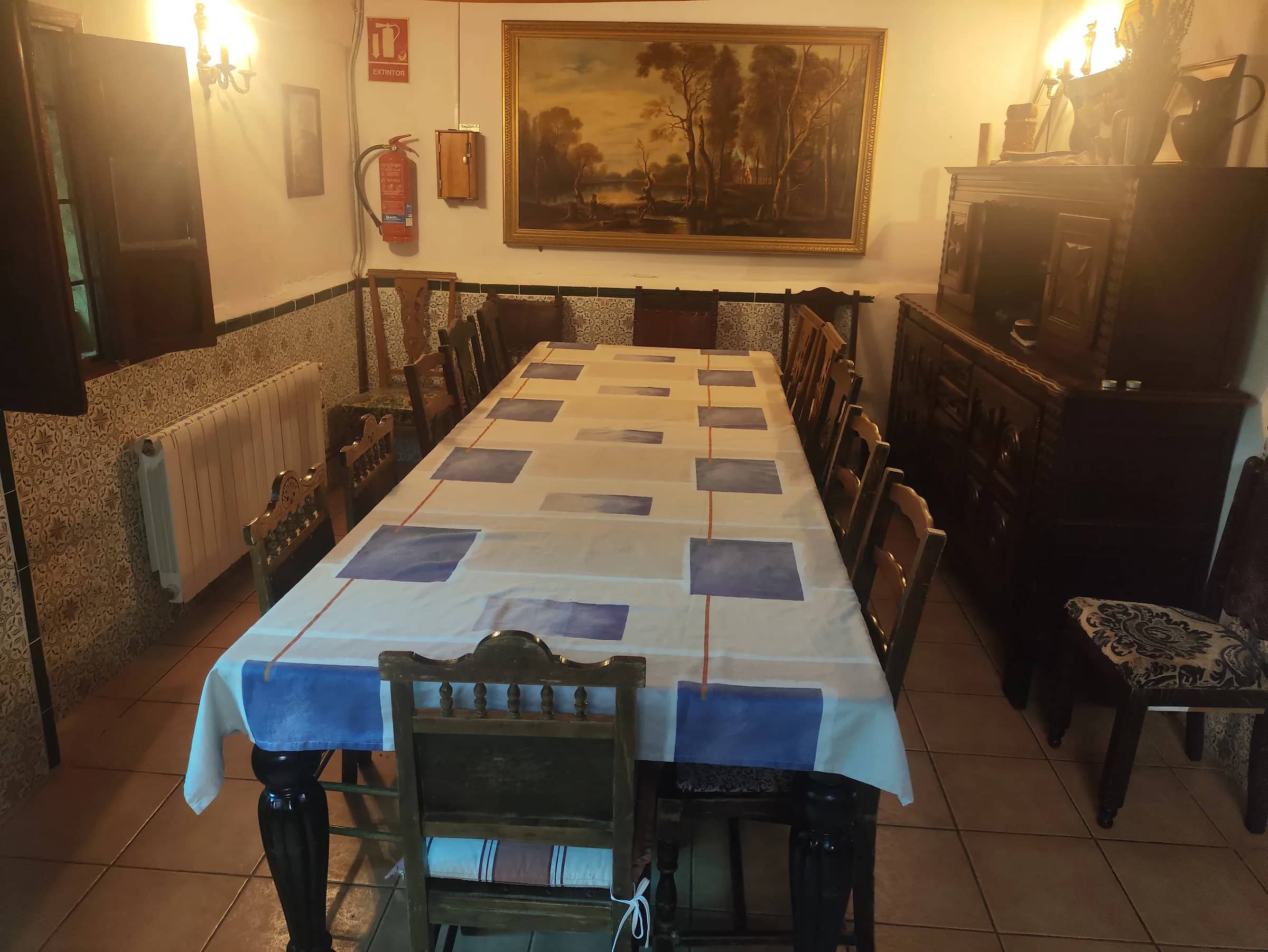 Comedor principal con mesa larga vestida para catorce personas