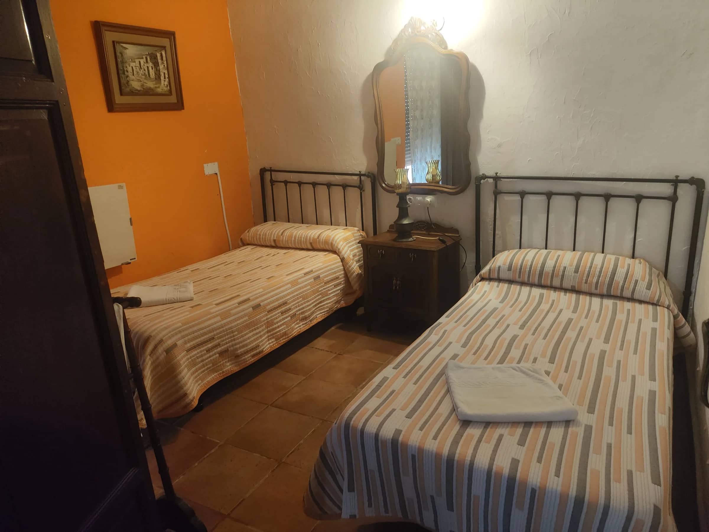 Habitación con dos camas individuales y cabeceros de forja en la planta baja