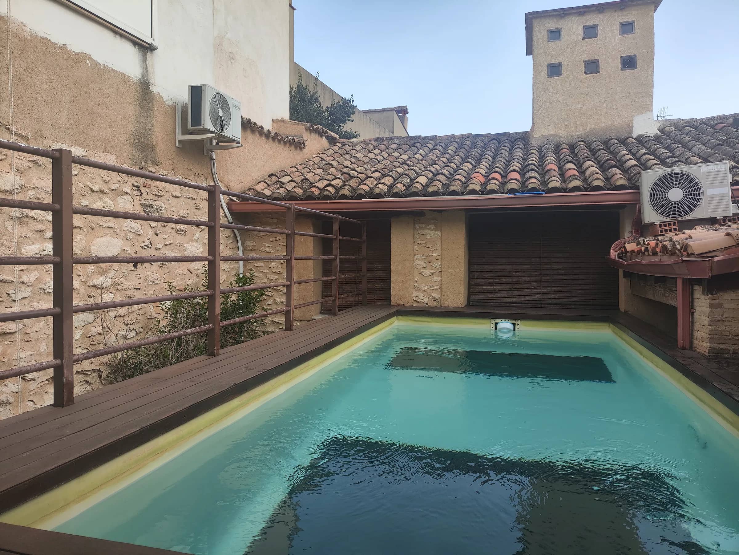 Piscina privada al aire libre con tejado de teja árabe y escalera de acceso