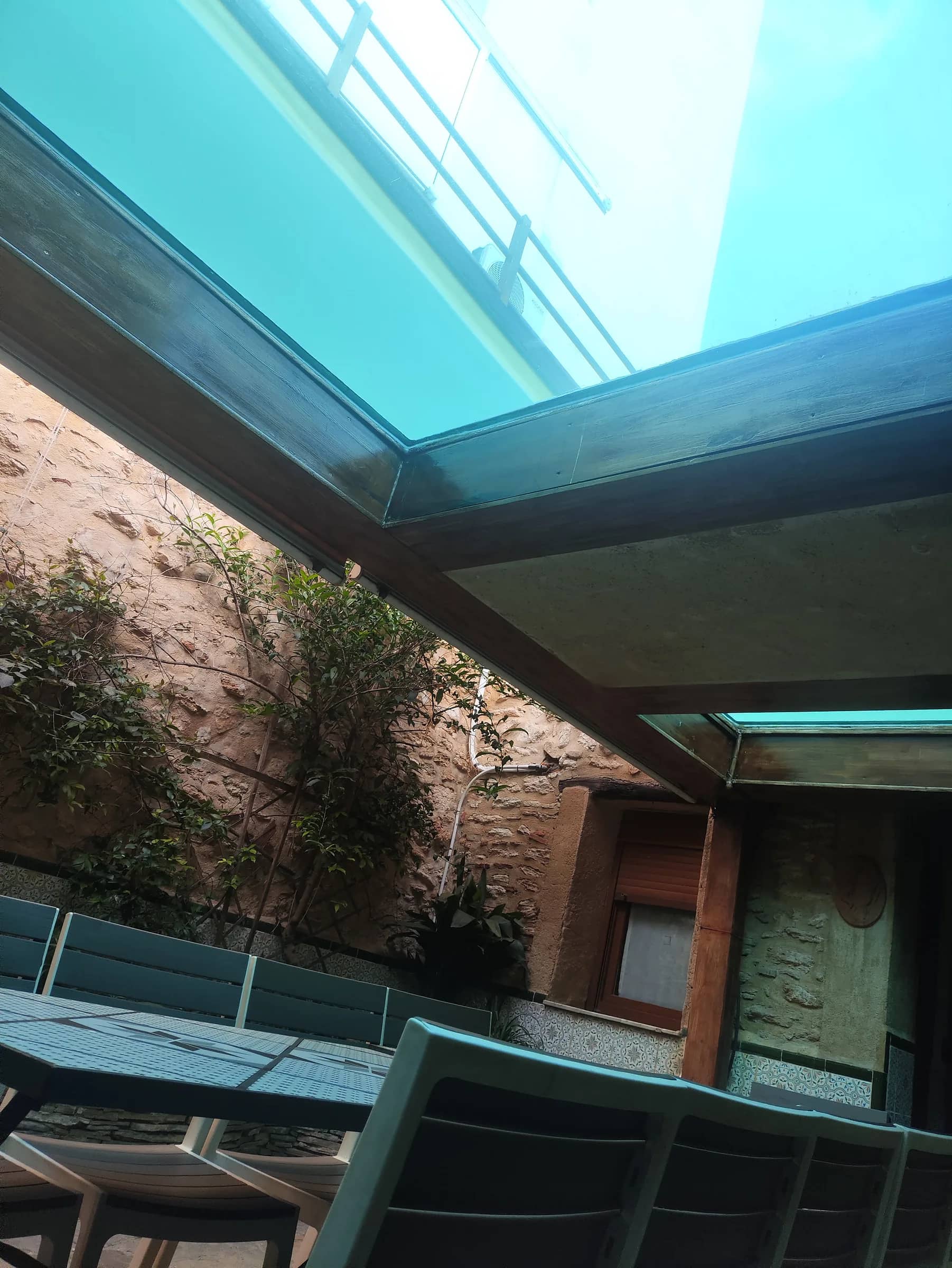 La piscina vista desde abajo: el suelo de cristal deja pasar la luz del agua al patio