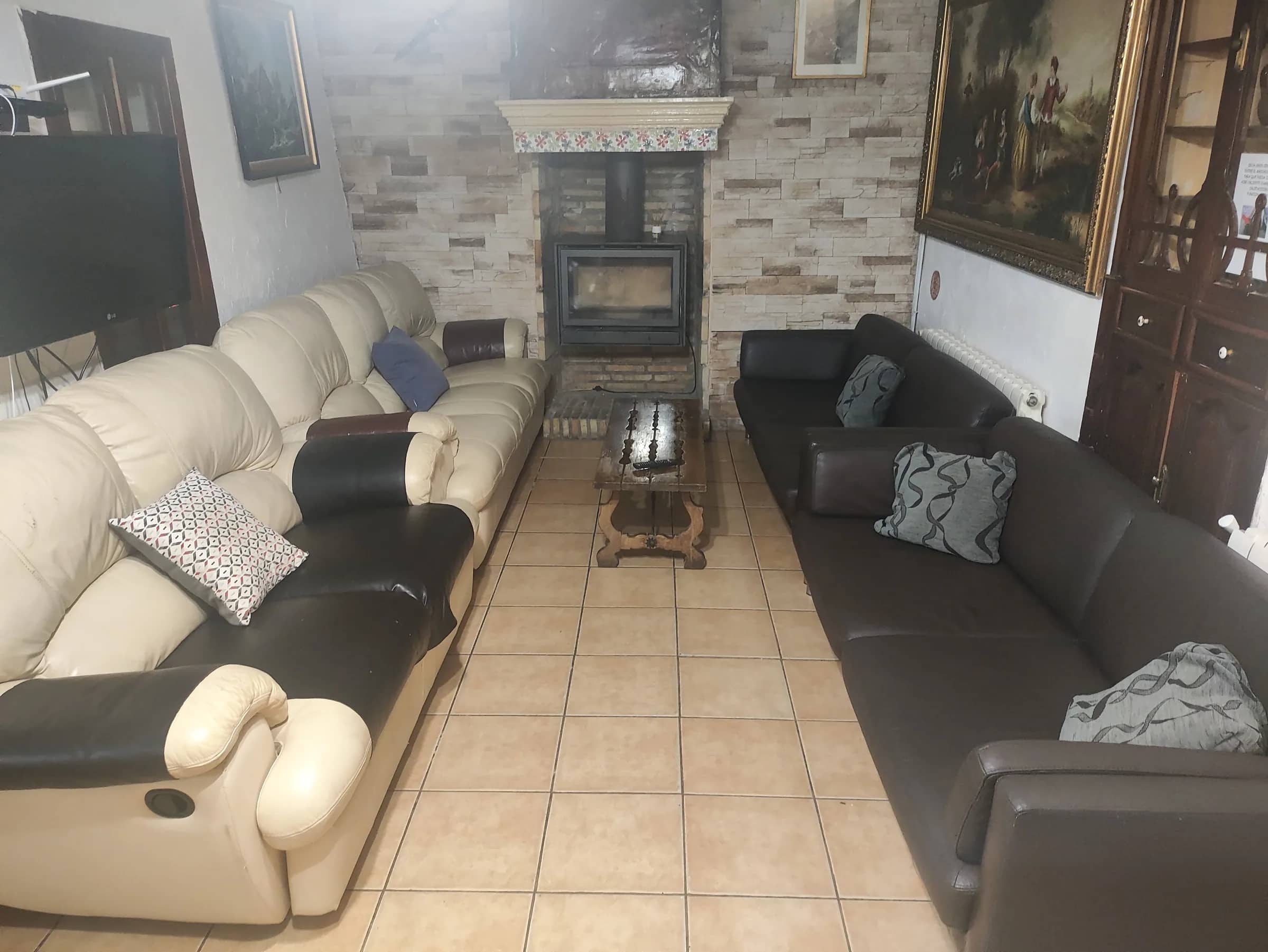 Salón con estufa de leña, sofás amplios y televisión para todo el grupo